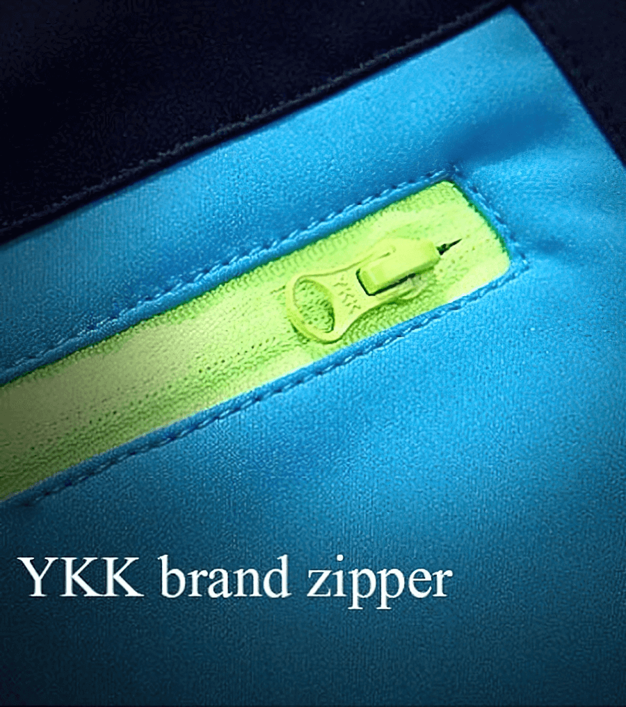 Close-up of YKK brand zipper on blue waterproof skiing pants for durability and cold resistance.